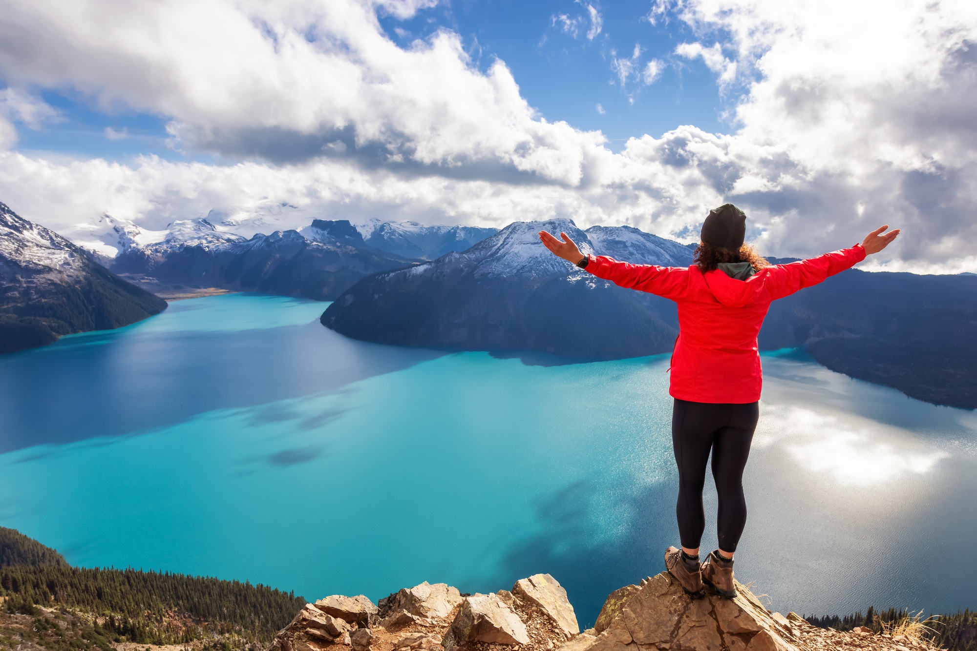 Adventurous Caucasian Woman hiking on top of a Canadian mountain